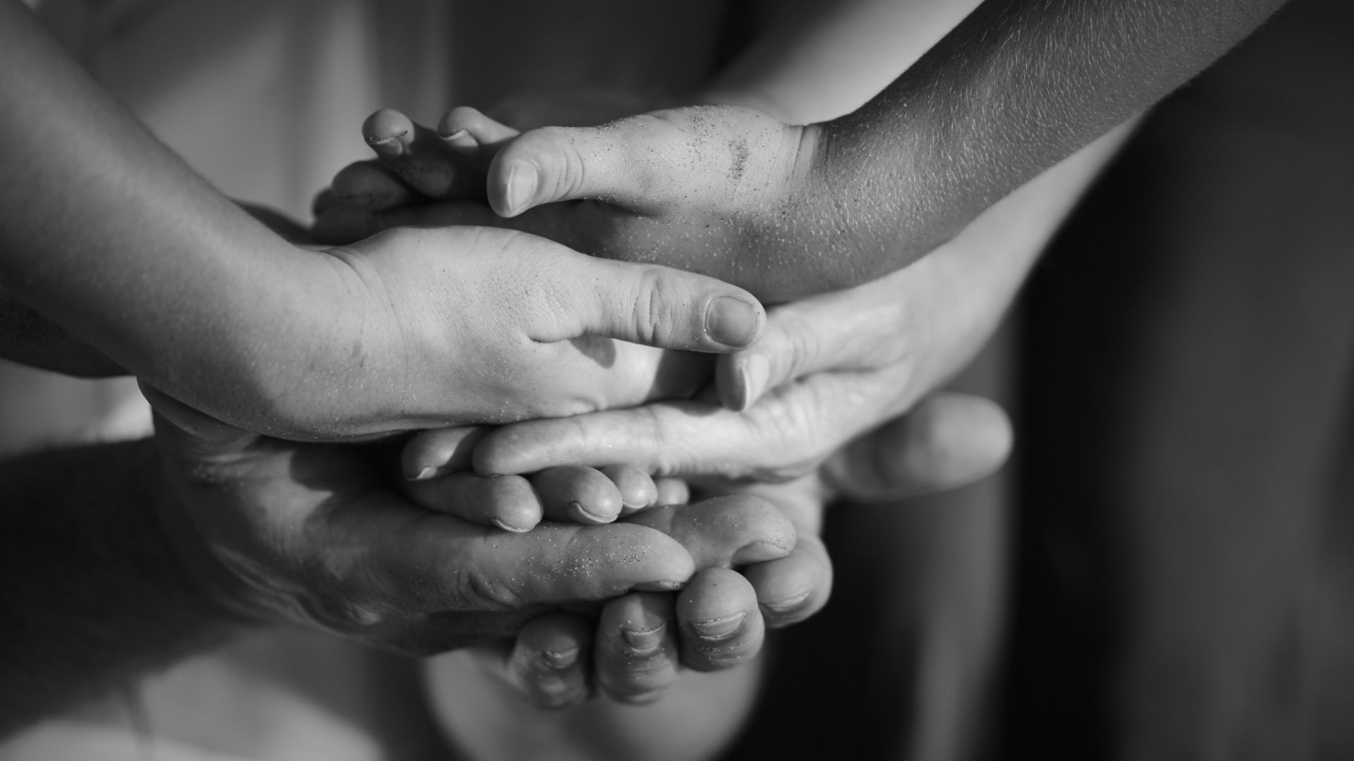 Black and white image of hands stack on each other